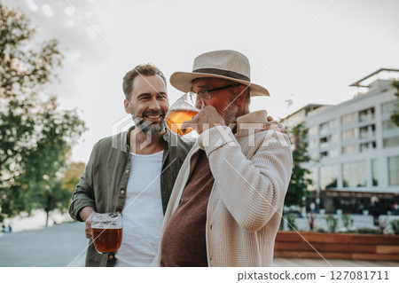 Happy father and son sharing drinks on a sunny day Happy father and son sharing drinks on a sunny day 127081711