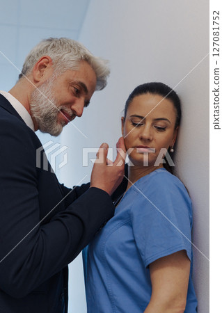 Hospital manager harassing attractive nurse in healthcare setting. 127081752