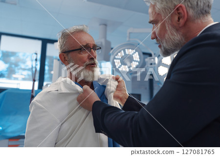 Aggressive man have conflict with doctor, holding him by coat. Aggressive man have conflict with doctor, holding him by coat. 127081765