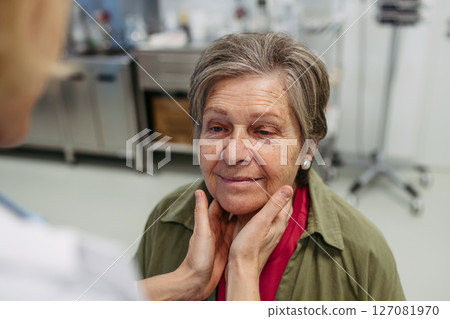 Doctor palpating lymph nodes during medical examination of senior patient. 127081970