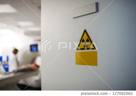 CT scan in progress behind radiation warning sign CT scan in progress behind radiation warning sign 127082002