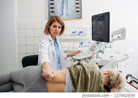 Medical examination with ultrasound probe on lower back Medical examination with ultrasound probe on lower back 127082030