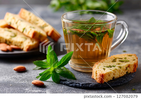 elegant presentation of herbal tea paired with almond biscotti 127082079