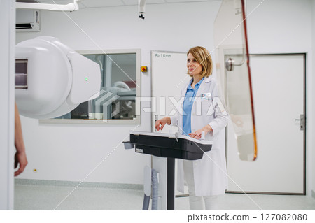Doctor operating dynamic X-ray scan using tilting fluoroscopy unit 127082080