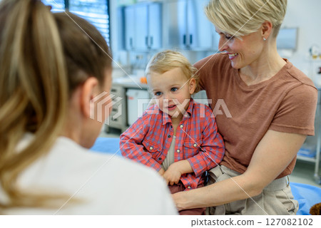 Pediatrician examing little boy during preventive health check up. 127082102