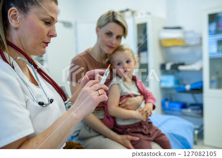 Toddler getting vaccinated during pediatric checkup. Toddler getting vaccinated during pediatric checkup. 127082105