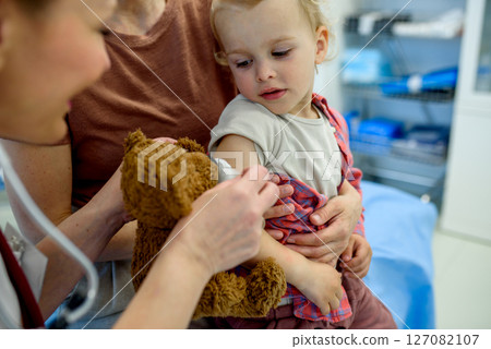 Doctor placing cotton and medical tape on the injection spot. Doctor placing cotton and medical tape on the injection spot. 127082107
