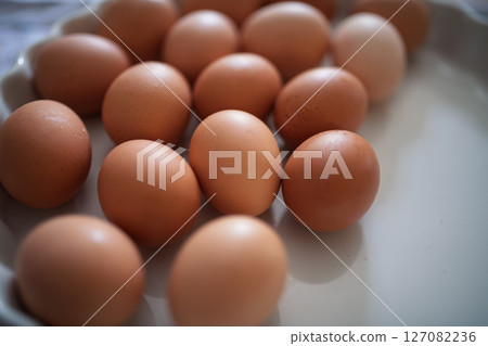 Fresh brown eggs in porcelain bowl 127082236