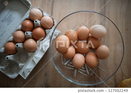 Fresh brown eggs in carton and glass bowl Fresh brown eggs in carton and glass bowl 127082249