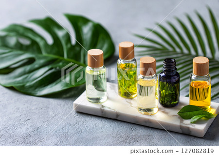 aromatherapy oils on marble with tropical leaves, wellness spa concept, mood relaxation 127082819