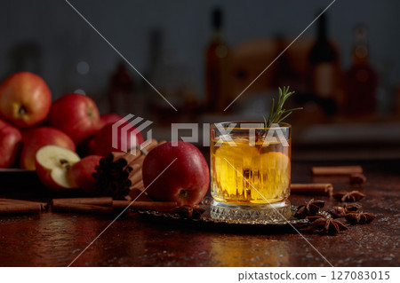 Apple kombucha with apple slices and a rosemary sprig. 127083015