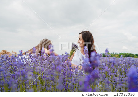 In the lavender field, a young mother waits for her little daughter 127083036