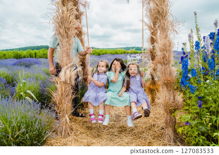 A swing, wrapped in dry grass, stands in the middle of a lavender field A swing, wrapped in dry grass, stands in the middle of a lavender field 127083533