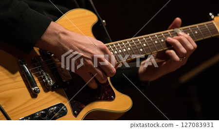 Tight close up of skilled hands playing guitar strings showing finger positioning tension and emotional connection to music Tight close up of skilled hands playing guitar strings showing finger positioning tension and emotional connection to music 127083931