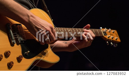 Tight close up of skilled hands playing guitar strings showing finger positioning tension and emotional connection to music Tight close up of skilled hands playing guitar strings showing finger positioning tension and emotional connection to music 127083932