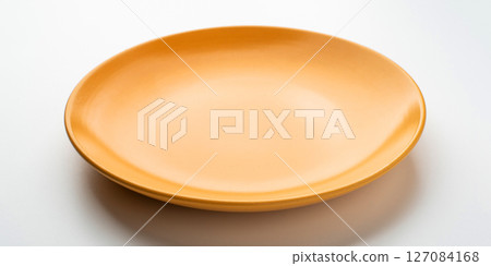 Yellow ceramic plate on a white table. Yellow ceramic plate on a white table. 127084168