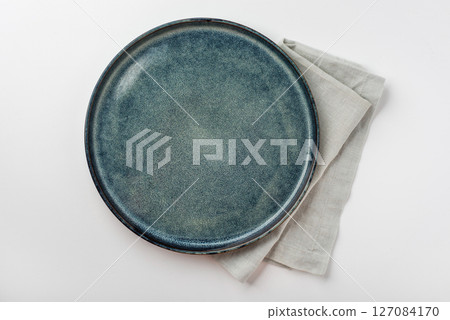 An empty grey textured plate on a white table An empty grey textured plate on a white table 127084170