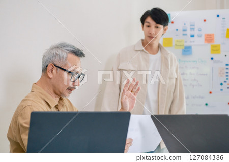 Asian senior bootcamp team asking and  learning programming with software training and whiteboard collaboration 127084386