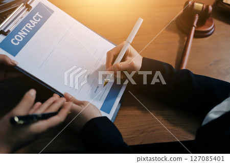 Judge gavel with Justice lawyers having team meeting at law firm background. Concepts of Law and Legal services. 127085401