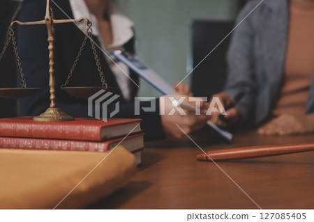 Judge gavel with Justice lawyers having team meeting at law firm background. Concepts of Law and Legal services. 127085405