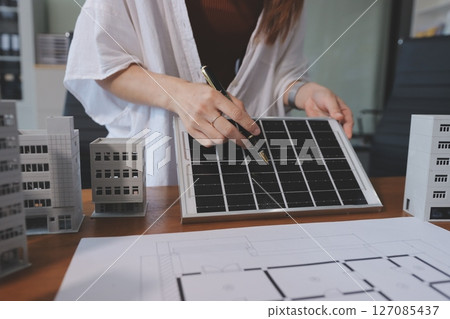 Discussion among businesspeople on the latest developments in solar cell panel technology and Solar Energy Environment city Concept. 127085437
