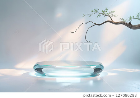 A modern minimalist setting featuring a transparent glass table with a smooth, rounded shape, set against a softly illuminated background. 127086288