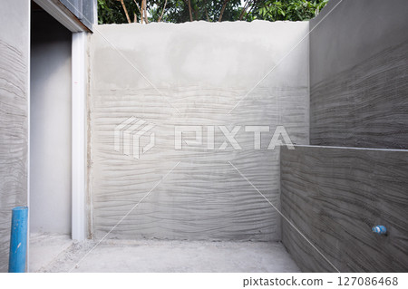 Concrete plastering wall and scrate surface to prepare for tile installation. 127086468