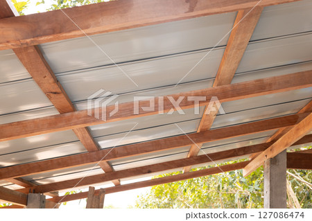 Roof under construction with metal sheet and wood structure. 127086474