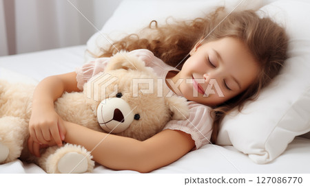 Cute little girl sleeping with teddy bear in bed 127086770