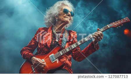 Ageless rock star grandmother with electric guitar, exuding confidence and passion on stage, captivating audience 127087713