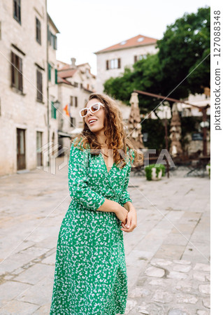 Happy female tourist in beautiful dress walking in the street of the city. Fashion style. Travel. Happy female tourist in beautiful dress walking in the street of the city. Fashion style. Travel. 127088348