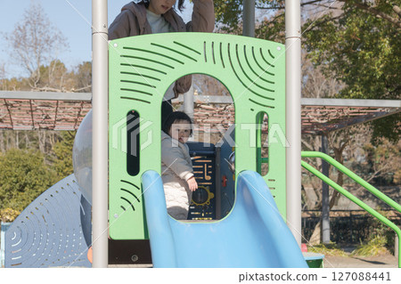 [一歲兒童與母親在相模原市麻溝公園的兒童遊樂場玩耍] 127088441