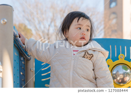 [相模原市麻溝公園兒童遊樂場，一歲兒童在溜滑梯上玩耍] 127088444
