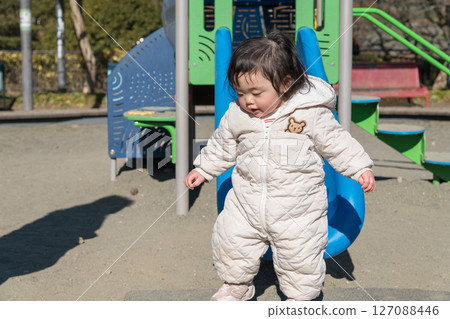 [相模原市麻溝公園兒童遊樂場，一歲兒童在溜滑梯上玩耍] 127088446