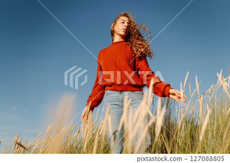 Beauty woman enjoying nature outdoors in grass. Calmness and tranquility. Travel, tourism concept. 127088805
