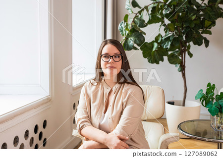 businesswoman with glasses in the office or psychologist. Portrait of a body-positive woman businesswoman with glasses in the office or psychologist. Portrait of a body-positive woman 127089062