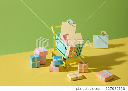A creative paper-cut composition featuring a shopping trolley with colorful items, representing retail therapy and fun weekend purchases in a minimalist style. 127089130