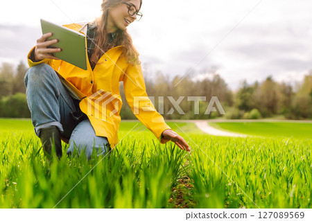 Innovative smart farm system technology, agricultural management. Farmer with tablet in green field 127089569