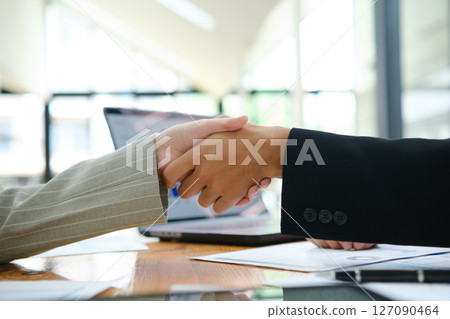 Two business people discuss financial strategy and collaborate with colleagues. Two business people discuss financial strategy and collaborate with colleagues. 127090464