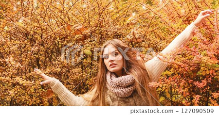 Mystery woman against autumnal leaves outdoor 127090509