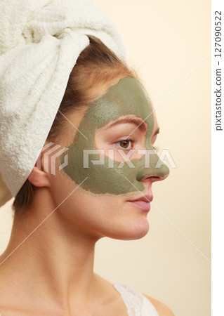 Woman face with green clay mud mask Woman face with green clay mud mask 127090522