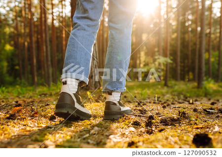 Feet of an adult wearing boots to travel walking in the forest. Feet walking in outdoor nature Feet of an adult wearing boots to travel walking in the forest. Feet walking in outdoor nature 127090532