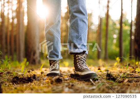 Feet of an adult wearing boots to travel walking in the forest. Feet walking in outdoor nature Feet of an adult wearing boots to travel walking in the forest. Feet walking in outdoor nature 127090535