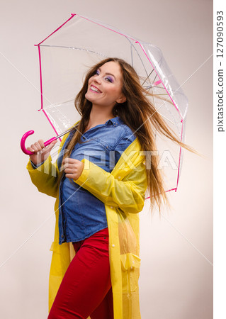 Woman wearing waterproof coat under umbrella 127090593