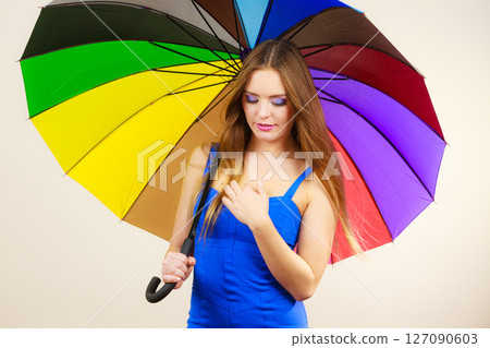 Woman in summer dress holds colorful umbrella 127090603