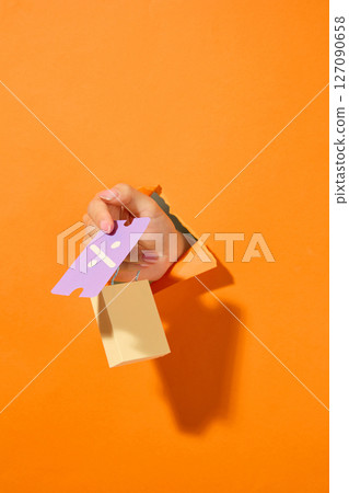 Clean layout of an arm sticking out of a paper background with a voucher card, ideal for digital retail platform imagery, attractive voucher tossing 127090658