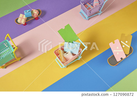 Top-down shot of colorful paper elements forming a sale scene. Shows variety in product choices and visual styles during seasonal discounts. 127090872