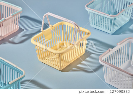 Empty shopping baskets of various colors are neatly arranged on a pastel blue background. Shopping-themed art photography, items representing a happy shopping journey 127090883