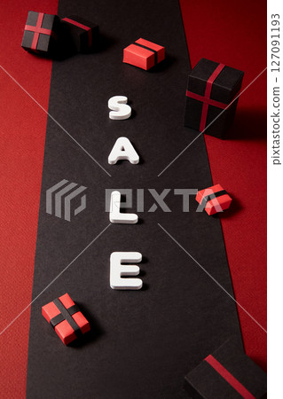 SALE letters split across red and black background, accentuated by floating gift boxes. Strong, direct imagery for discount-driven campaigns 127091193