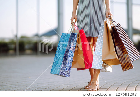 Shopping time. Young woman with shopping bags near the mall. Consumerism, sale, purchases. 127091298